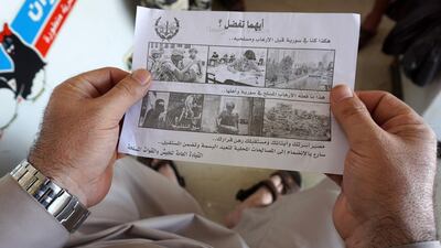 A man holds a leaflet dropped by helicopters over the Syrian city of Saraqib on August 9, 2018. AFP