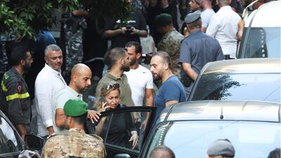 A woman who was held hostage inside the Federal bank of Lebanon enters a car after her release. Reuters