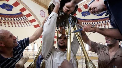 Workers install the first ring of the chandelier at the Al Farooq mosque in Al Safa area in Dubai.