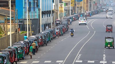 Motorised rickshaw drivers queue along a street to buy petrol from a fuel station in Colombo. AFP
