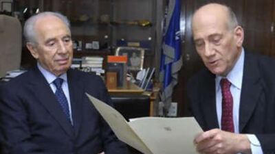 In this photo released by Israel's Government Press Office, Israeli Prime Minister Ehud Olmert, right, reads his resignation letter to the Israeli president Shimon Peres as he hands in his resignation at the President's residence in Jerusalem on Sept 21 2008.