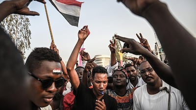 Sudanese protesters wave national flags and shout slogans during a protest outside the army headquarters in the capital Khartoum. AFP