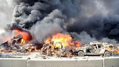 Flames and smoke raise from burning cars after two bombs exploded, at Qazaz neighborhood in Damascus, Syria, on Thursday May 10, 2012. Two large explosions ripped through the Syrian capital Thursday, heavily damaging a military intelligence building and leaving blood and human remains in the streets. (AP Photo/SANA)