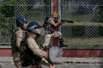 An Indian policeman fires a pellet gun at Kashmiri protesters after Eid prayers in Srinagar on Saturday. AP
