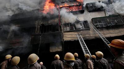 Emergency services stare upwards at the inferno. EPA