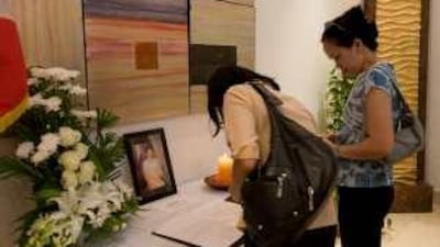 Filipinas sign the book of condolence for Corazon Aquino at the Philippine embassy in Abu Dhabi.