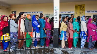 People stand in a queue to cast their votes at a polling station in Dharmsala, India. Ashwini Bhatia / AP Photo