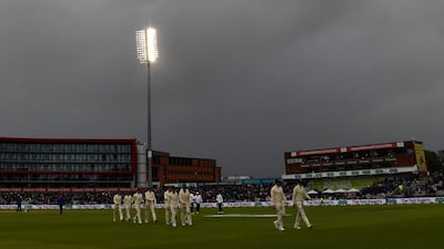 Players leave the field as rain delays play on the first day. AFP