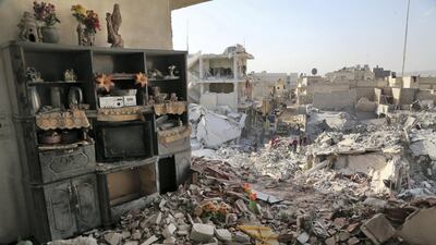 Shelves remain standing amidst the rubble on November 14, 2017 following an air strike the previous day on the northern rebel-held Syrian town of Atareb. Three strikes hit the northern town of Atareb on Monday, the Syrian Observatory for Human Rights said, despite a "de-escalation zone" in place there. / AFP PHOTO / Zein Al RIFAI