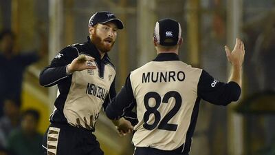 New Zealand's Martin Guptill (L) celebrates with Colin Munro after taking the catch of Pakistan's Ahmed Shehzad during the World T20 cricket match between New Zealand and Pakistan at the Punjab Cricket Stadium Association Stadium in Mohali on March 22, 2016. / AFP / MONEY SHARMA