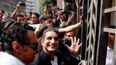 Egyptian television satirist Bassem Youssef, who has come to be known as Egypt's Jon Stewart, waves to his supporters as he enters Egypt's state prosecutors office to face accusations of insulting Islam and the country's Islamist leader.