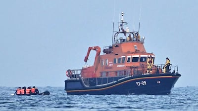 An RNLI lifeboat pick up migrants in an inflatable boat who were travelling across the English Channel, bound for England. AFP