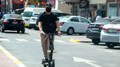 An e-scooter rider heads into oncoming traffic on Hamdan Steet, central Abu Dhabi. Victor Besa / The National