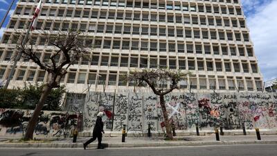 A woman wearing a protective mask walks past Central Bank building in Beirut, Lebanon, May 5, 2020. Reuters