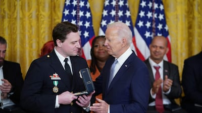 Metropolitan Police Department Officer Daniel Hodges receives his medal. 'To all the families here who lost someone, this country thanks you,' Mr Biden said. AFP