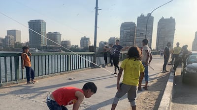 Egyptian boys flying kites off a Nile bridge in Cairo. Hamza Hendawi for The National