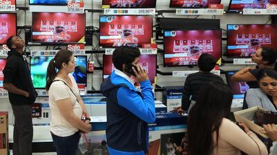 Shoppers stand in a checkout line during Black Friday sales at store in California. David McNew / Reuters