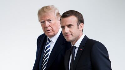 President Donald Trump and French President Emmanuel Macron walk through the Colonnade before heading to the Oval Office at the White House in Washington. Brendan Smialowski / AFP