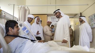 An injured UAE serviceman smiles as Sheikh Mohammed bin Zayed and Sheikh Hamdan bin Mohammed bin Zayed, right, pays him and his relatives a visit.