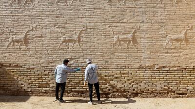 Workers clean salt deposits from a wall decorated with animal reliefs at Babylon, a UNESCO World Heritage site, in Babylon, Iraq. Experts warn that rising soil salinity and previous restoration errors are accelerating the deterioration of Iraq’s archaeological heritage. Reuters