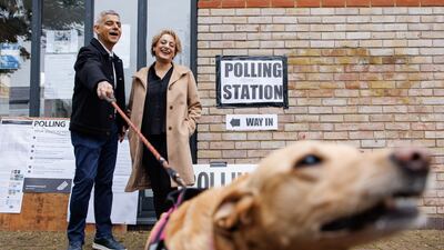 London mayor Sadiq Khan and his wife Saadiya pose for the media with their dog Luna, as they arrive at a polling station in the British capital. EPA