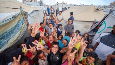 Palestinian children celebrate at a camp for displaced people in Nuseirat, central Gaza, following news of the ceasefire deal. AFP