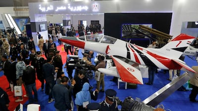 Visitors surround a training plane at the Egyptian booth during the first arms fair organized in Cairo. AP