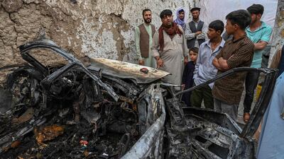 Afghan residents and family members of the victims gather next to a damaged vehicle inside a house day after a US drone air strike in Kabul in August. AFP