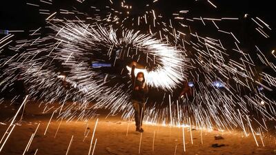 A Palestinian boy waves fireworks as people celebrate the start of the Muslim holy fasting month of Ramadan in the southern Gaza Strip town of Rafah. AFP