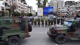 Syrian troops standing guard in Latakia on Sunday as the Alawite community held mass protests. Reuters
