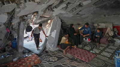 Sahar Taroush talks with her brother in her partially collapsed home in Jabalia, Gaza, after returning following the ceasefire. AP