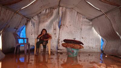 A Syrian boy sits in a water logged tent at the Cordoba camp for internally displaced Persons (IDP), close to Batabu town, along the highway leading to the Syrian Bab al-Hawa border crossing with Turkey, in the northern Syrian Idlib province. Following heavy rain storms, the camp has become water logged, flooding the tents and making the the roads muddy and difficult to maneuvre on. AFP
