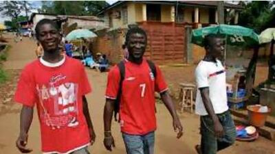 Kabba Williams, centre, walks with two other former child soldiers in Lumley, a village on the outskirts of Freetown.