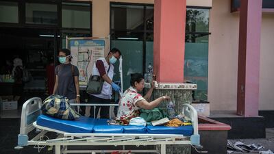 An injured woman sits on a stretcher outside a hospital in Palu. Getty Images