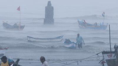 A fisherman waits for help as he tries to move a fishing boat to a safer ground on the Arabian Sea coast in Mumbai on Monday. Authorities tried to evacuate hundreds of thousands of people as Cyclone Tauktae moved into India's western coast. AP Photo