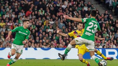 Barcelona's Sergio Busquets scores past Real Betis' Alex Moreno, left, and Aissa Mandi during their match at the Benito Villamarin Stadium. AP