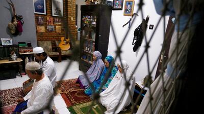 Tatan Agustustani, a 52-year-old Muslim man, prays with his family inside their house in Bogor, near Jakarta, Indonesia. Reuters