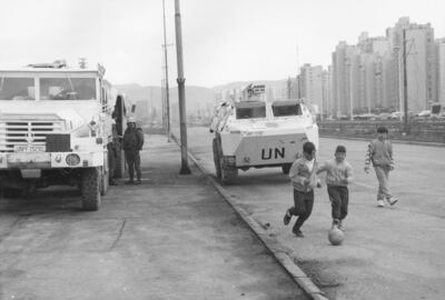 Children play football beside UN vehicles in Sarajevo during the civil war in September 1993. Getty Images
