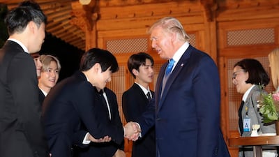 US President Donald J. Trump shakes hands with a member of South Korean boy group Exo during his visit to the South Korean presidential office Cheong Wa Dae in Seoul to attend a welcome dinner hosted by President Moon Jae-in. EPA