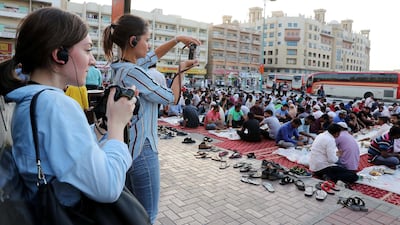 Participants in the Unseen Trails Iftar Walk take photos at the mosque iftar near Al Ghubaiba bus station in Bur Dubai area of Dubai. The event is presented by Gulf Photo Plus and Frying Pan Adventures. Pawan Singh / The National