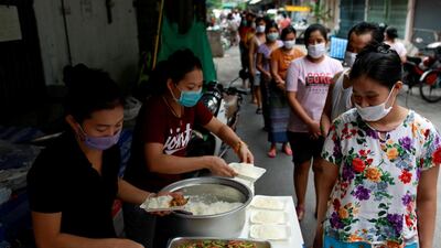 Volunteers give free food to migrant workers from Myanmar who lost their jobs following the coronavirus disease outbreak in Bangkok, Thailand. Reuters
