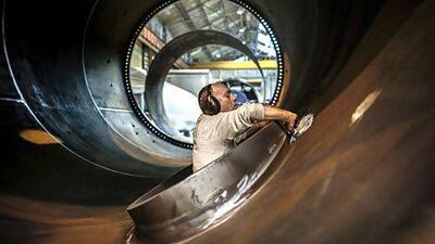 An employee works on a wind turbine tower at the FrancEole wind turbines factory in Le Creusot. Jeff Pachoud / AFP