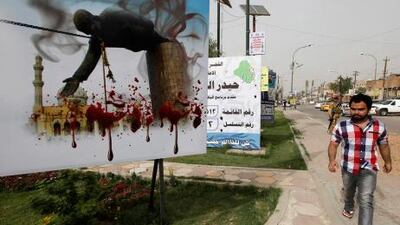 An Iraqi man walks past a billboard depicting the fall of a statue of dictator Saddam Hussein in Baghdad.