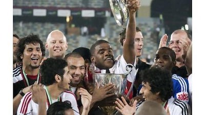 Al Jazira players crowd around to touch the President's Cup in a moment that will go down in the club's history.