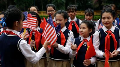 Children are handed flags before President Donald Trump arrives to meet with Vietnamese President Nguyen Phu Trong at the Presidential Palace in Hanoi. AP Photo