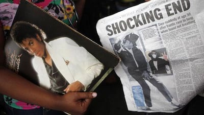 A woman holds a copy of the album 'Thriller' at the Apollo Theater in New York.