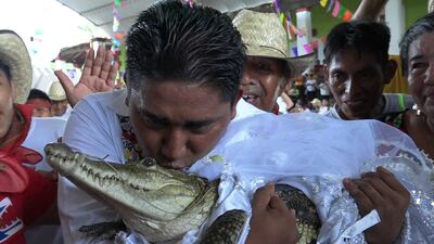 Victor Hugo Sosa, mayor of San Pedro Huamelula, Mexico, kisses a caiman called 'La Nina Princesa' before marrying the alligator-like reptile. AFP