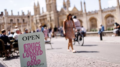 People walk past a shop sign outside King's College at University of Cambridge in Cambridge. Professor of sociology of education Jason Arday resigned from the university this month amid plagiarism allegations and scrutiny of claims about his academic history. EPA