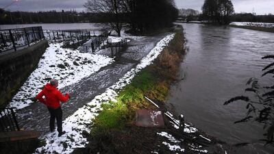 A council inspector examines a bridge and checks the water level on the River Mersey in Didsbury. AFP