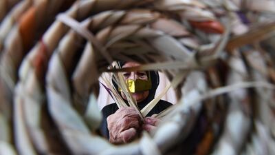 An Emirati woman weaves.